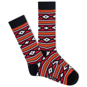 A pair of men's crew socks with a southwestern striped pattern in orange, red, white, and black colors.