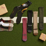 Collection of socks with brand name on a grass-like surface with small gift boxes. thumbnail