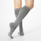 Back profile of a person wearing gray Dr. Scholl's knee high compression socks.