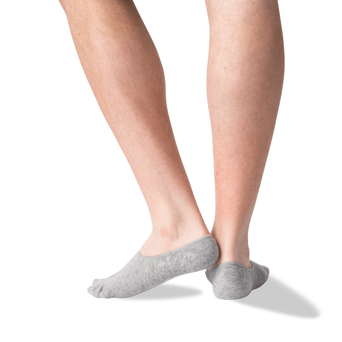 A close-up of a person's lower legs and feet wearing light gray low-cut no-show socks against a plain white background.