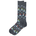 A pair of dark gray crew socks featuring a repeating pattern of penguins wearing red and green hats and scarves, standing on icy blue platforms with white snowflakes.