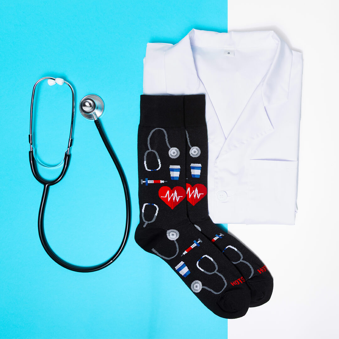 Black socks with medical-themed designs, a white lab coat, and stethoscope on a blue background