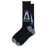 A pair of black crew socks with gray heels and toes, featuring a graphic of a Bigfoot silhouette under a UFO with the word 'BELIEVE' in green.