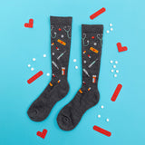 Gray knee-high socks with medical-themed pattern on a blue background with red and white accents.