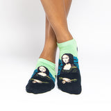 A person's feet wearing low-cut socks featuring a split design: light green on the upper half and black on the lower half, with a printed portrait of the Mona Lisa on the front. thumbnail