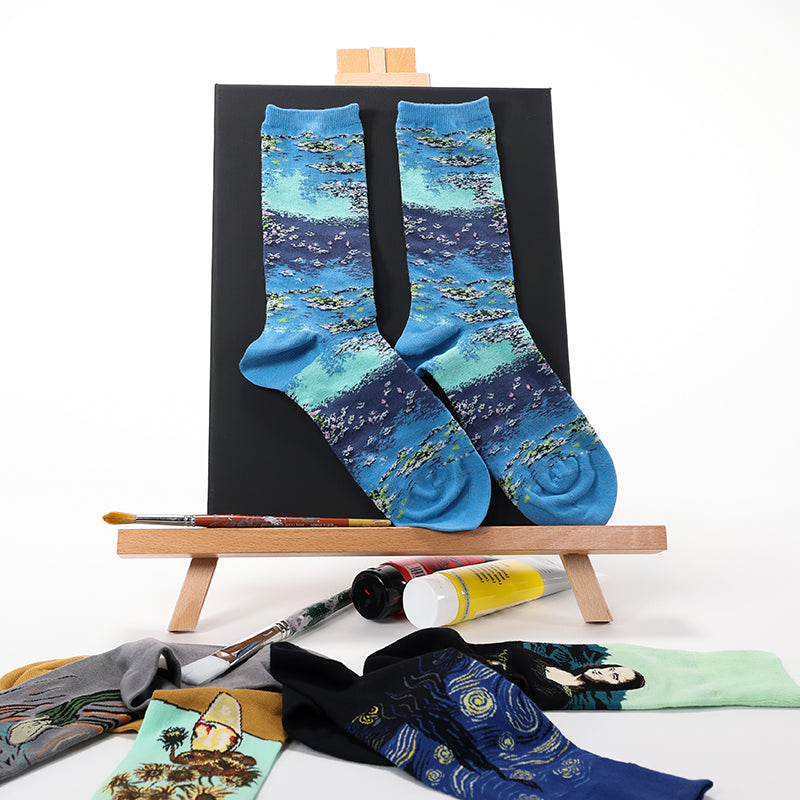 Pair of socks with artistic design on a small easel with art supplies.