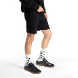 Person wearing black shorts, black sneakers, and white socks with palm tree design on a white background thumbnail