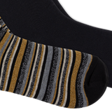 A close-up of a black sock with vertical glittery stripes in gold, gray, and black, and the second sock being solid black, shown against a plain white background. thumbnail
