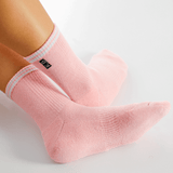 Pink socks with white stripes worn by a person on a light gray background thumbnail