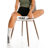 Person sitting on a chair with 'Iconic' branding, wearing matching socks and shorts. thumbnail