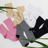 K.Bell striped and solid microfiber crew socks in various colors and patterns on a white background on a light background with green leaves
