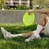 Person sitting on grass holding a yellow frisbee thumbnail