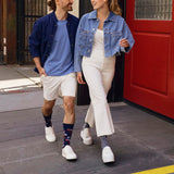 Two people walking on a sidewalk wearing denim jackets and white pants. thumbnail