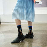 Person wearing socks with art-themed designs in a room.