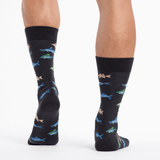 Black socks with colorful fish pattern worn by a person on a white background thumbnail