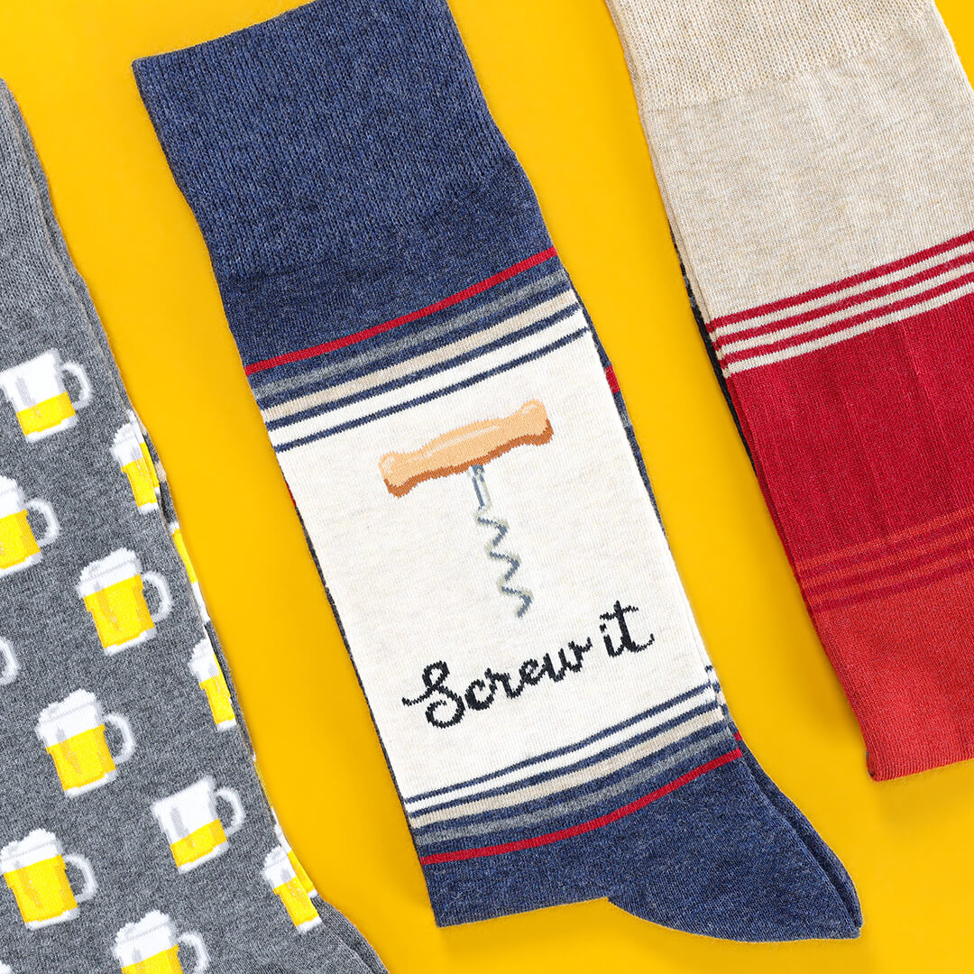 THhree pairs of socks with different alcohol designs on a yellow background
