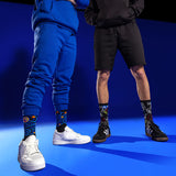 Two people wearing colorful socks with famous painting designs on a blue background