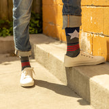 Person wearing star-patterned socks with a yellow wall in the background thumbnail