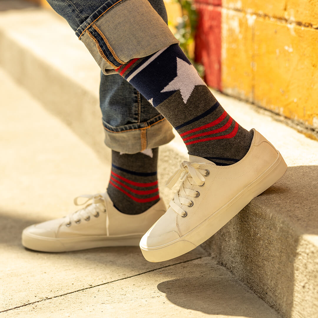 Person wearing patriotic-themed socks with a star design, standing on a concrete surface.