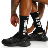 Person wearing black running shoes and socks with text on a white background