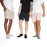 Three men wearing different colored shorts on a white background