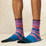 Colorful striped socks worn by a person on a neutral background
