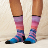 Multicolored striped socks worn by a person on a neutral background thumbnail