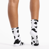 White socks with black cow print worn by a person on a white background thumbnail