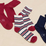 Set of red, white, and blue striped socks with a brand logo on a beige background thumbnail