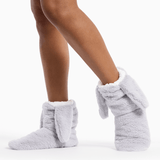Gray fuzzy slippers worn by a person on a white background thumbnail