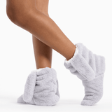 Gray fuzzy socks worn by a person on a white background