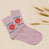 Pink sock with floral design and text on a beige background