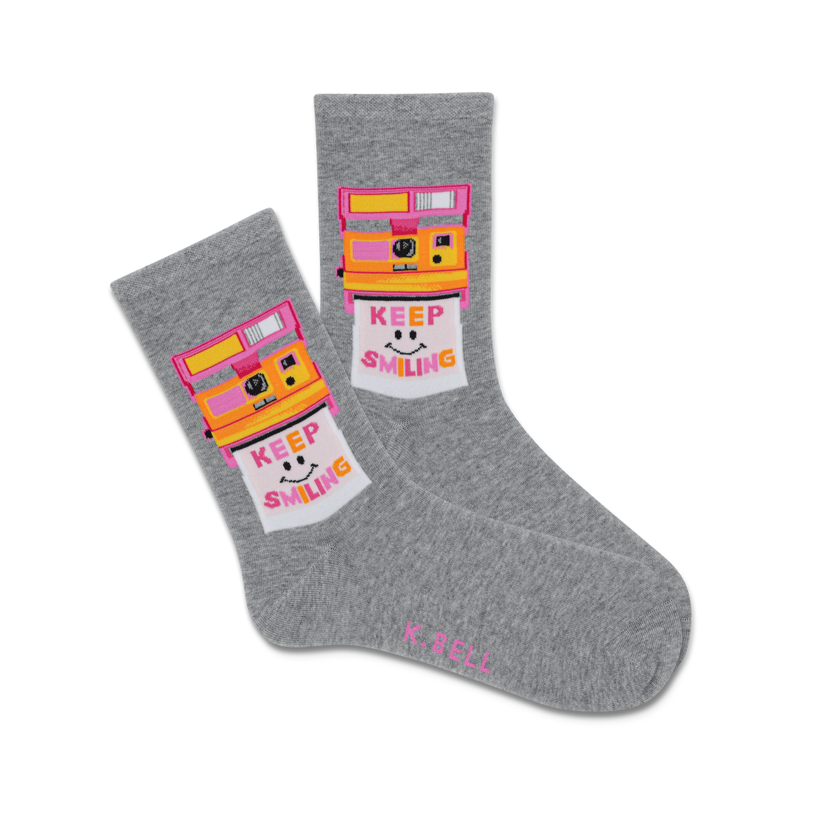A pair of gray crew socks with a vintage camera design and the text 'KEEP SMILING' in a colorful background.