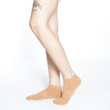 Beige socks worn by a person on a white background thumbnail
